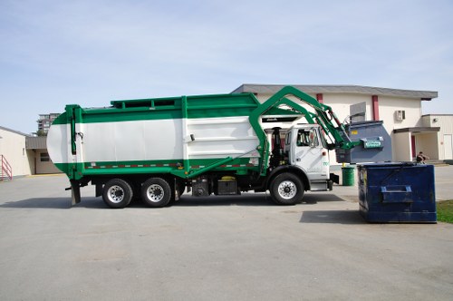 Front of a skip with company logo and a city street background